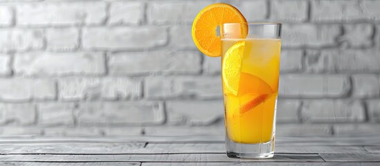 Poster - Glass of fresh orange juice with fruit slice on a table against a white brick wall background Copy space image included