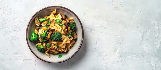 Poster - Top down view of a dish featuring farfalle pasta roasted broccoli and sauteed mushrooms in a bowl on a white backdrop with empty space for text or images. Creative banner. Copyspace image