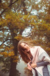 © Mallivan - Happy woman in a warm pink scarf in a foggy autumn forest