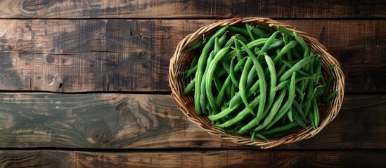 Aufkleber - Top view of a cane basket with freshly picked green French beans on a wooden surface with room for a separate image alongside. Creative banner. Copyspace image
