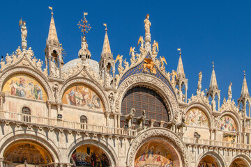 Basilica di San Marco or St Mark's Basilica, Venice, Italy. It is the main travel attraction of Venice. Luxury facade of St Mark's church close-up. Ornate detail of landmark of Venice in summer.