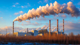 Elektrownia z kominami wytwarzającymi dym, z niebieskim niebem w tle. Obrazek pokazuje emisję CO2 do atmosfery i podkreśla wyzwania związane z zanieczyszczeniem powietrza oraz rynek handlu emisjami.