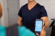© Wavebreak Media - Handing smartphone with verification screen to medical professional in medical clinic