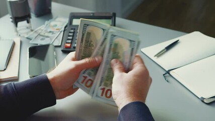 Canvas Print - Counting cash at a desk with a calculator, organized finances, and office supplies in a bright setting