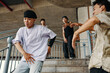 © DragonImages - Group of young dancers practicing hip-hop moves on outdoor staircase displaying energetic movements and coordination