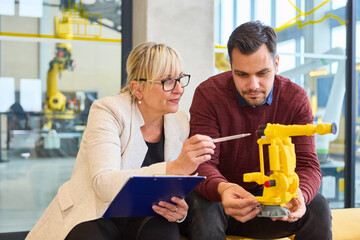 Engineers discussing robot design in a lab for industrial automation and production