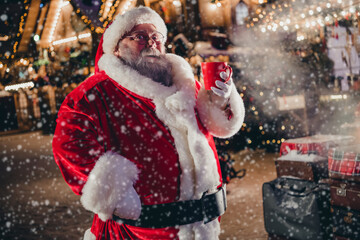 Wall Mural - Photo of retired positive man hold mug delicious tasty beverage eggnog hot chocolate tea enjoy spending time midnight snowy street outside