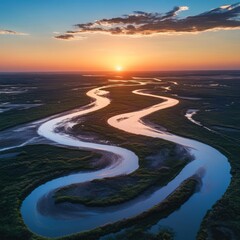 Poster - A winding river flows through a lush green landscape, with the sun setting in the distance. The sky is a vibrant blend of orange, pink, and blue, creating a stunning scene.