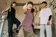 © DragonImages - Group of young Asian friends hanging out on outdoor stairway exuding confidence and playful energy. Individuals are wearing casual streetwear and making expressive gestures