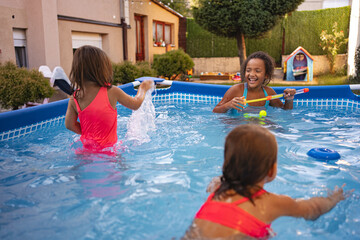 Children playing happily in a backyard pool during a sunny afternoon