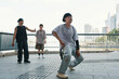 © DragonImages - Group of dancers showcasing breakdance skills in urban city overlooking modern buildings and skyline creating dynamic street art performance with cityscape backdrop