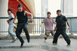 © DragonImages - Group of dancers practicing street dance routine under urban bridge during daytime capturing dynamic movements and energy of each participant