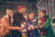 © deagreez - Photo of full family four member x-mas meeting gathering hold hold bengal fire listen president congratulation noel mood outerwear hat scarf coat evening street illumination outdoors outside