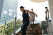 © DragonImages - Group of young adults ascending outdoor stair structure with one person wearing black bandana and sleeveless top Leisure activity and sunny environment for gathering
