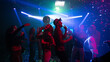© Videophilia - A group of people dancing happily under falling confetti in a modern nightclub decorated with multicolor lighting