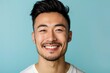 © sakuratanaka - Close up portrait of young handsome smiling Asian man face on light blue studio background