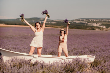 Wall Mural - women and girl standing in a field of lavender, holding flowers and smiling. They are in a small boat, which is floating on lavender