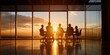 © gunzexx png and bg - Silhouettes of people participating in a meeting in a modern office building, with the setting sun creating a dramatic backdrop, conveying teamwork and corporate environment.
