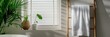 © gunzexx png and bg - A minimalistic bathroom setup featuring a towel hanging on a rack, a plant beside a sunlit window with blinds, creating a clean, serene, and natural ambiance in the restroom.