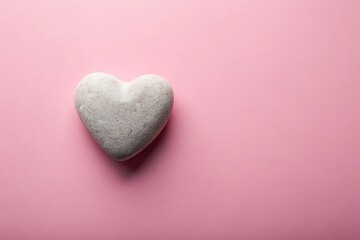 Wall Mural - Heart shaped stone resting on a soft pink background, close up, stone, creative, isolated, smooth, love, symbol, pink background,heart shaped, medium shot, concept, object, sentiment, natural