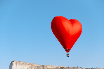 romantic heart balloon soars above majestic mountain range and ocean in dreamy sky