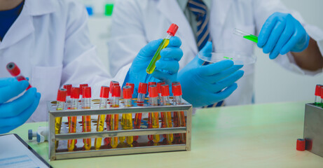 In this chemical experiment, two researchers collaborate to mix reactants, carefully observe changes such as color shifts or gas production, and analyze results, demonstrating principles of chemistry