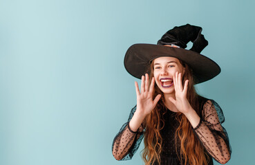 Poster - girl in Halloween witch costume on blue wall background