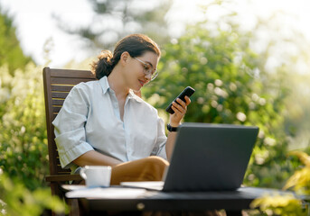 Wall Mural - woman working on laptop in summer morning