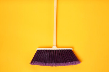 Canvas Print - One cleaning broom on orange background, top view