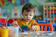 © Trissa - toddler boy drawing on paper in kindergarten