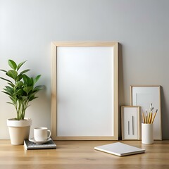 Canvas Print - A clean and minimalist desk mockup with a large. blank picture frame. a plant. a coffee cup. a notebook. and pencils in a vase.