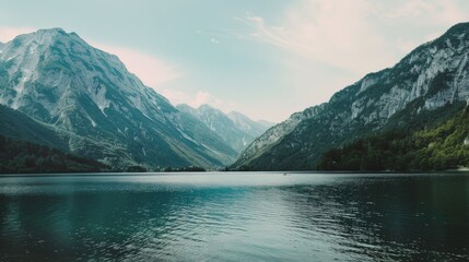 Stunning alpine lake encircled by towering snow-capped mountains under a vibrant blue sky.