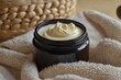 © Panuwat - Black jar cream placed beige towel is round Open black jar