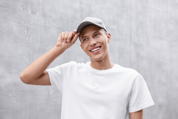 Poster - Portrait of smiling man in baseball cap near light wall