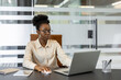 © Liubomir - African American businesswoman uses laptop in modern office setting. Displays focus, professionalism, and technology use within corporate environment, emphasizing productivity and career success.