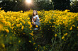© Maria Manco/Stocksy - Preteen smiles at camera in wildflower field