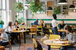 © Oleksii Syrotkin/Stocksy - Multiethnic people resting and spending time in comfortable cafe