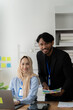 © Kritdanai - Confident Colleagues: A portrait of a young, diverse business team at their workspace, radiating professionalism and teamwork in a modern office setting.