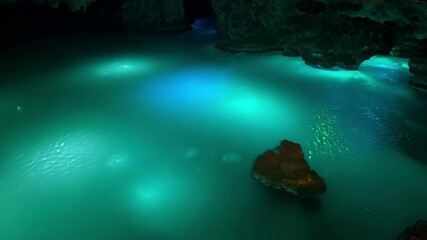 Aufkleber - Explore the mesmerizing turquoise water in a subterranean cave, glowing on rocky formations. Be captivated by this natural, illuminated scene, perfect for travel