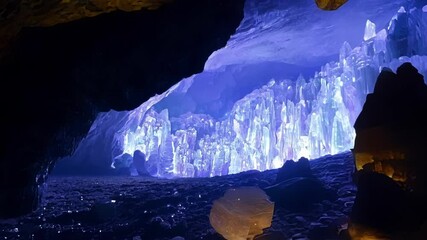 Aufkleber - Mesmerizing view inside a cave illuminated by an otherworldly blue light, showcasing stunning stalagmites and stalactites. The mystical atmosphere evokes a sense of wonder and fantasy