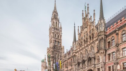 Wall Mural - Main facade of the New Town Hall (Neues Rathaus) building at the northern part of Marienplatz timelapse hyperlapse in Munich. Fischbrunnen fountain in front. Cloudy sky. Bavaria, Germany.