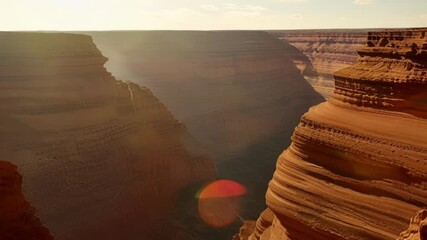 Poster - The sun shines on a majestic canyon, creating a warm glow over the rugged landscape, with orange, brown, and red rocks. Perfect for adventure seekers in the southwest usa
