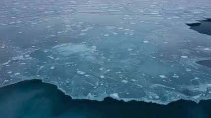 Aufkleber - Icy landscape shows a frozen ocean covered with ice sheets forming interesting geometric shapes and creating a mesmerizing view