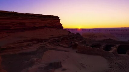 Poster - Captivating fantasy sunset over ancient city ruins in a desert landscape, with tall structures and old stone buildings revealing a mysterious civilization