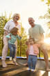 © Iuliia Versta/Stocksy - a senior couple with two grandchildren jumping on a trampoline