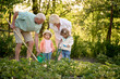 © Iuliia Versta/Stocksy - Little children working with their grandparents in the garden