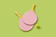 © Yaroslav Danylchenko/Stocksy - Crossed paddles for pickleball laying on green background