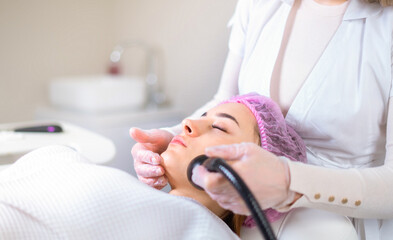 Young woman receiving treatment in cosmetology clinic. Cosmetology skin care. Aesthetic facial treatment Concept.