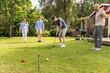 © Diego Martin/Stocksy - Family Playing croquet in Backyard