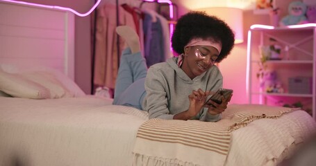 Poster - Home, typing and black woman with smartphone, bedroom and social media with message, internet and relax. African person, mobile user and girl with cellphone, texting and online chatting with smile